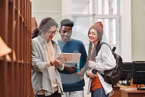 Group of Young People Using Digital Tablet in Library