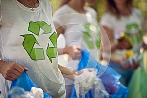 Group of young people volunteering, picking up trash. Cleaning nature from garbage. Environmentalism, green living, volonteering