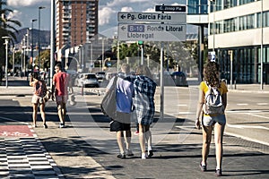 Group of young people are walking along the street.