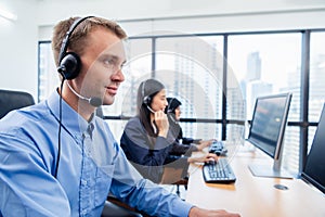 Group of young profession call center operator agent with headsets working in office. Business telemarketing service people