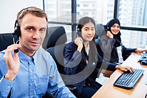 Group of young profession call center operator agent with headsets working in office. Business telemarketing service people