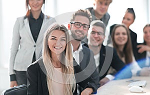 Group of young professionals sitting at an office Desk.