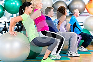 Group of young and senior people exercising in gym