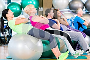 Group of young and senior people exercising in gym