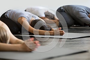 Group of young sporty people in Child pose