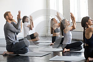 Group of young sporty people in Cow Face pose