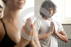 Group of young sporty people make namaste gesture, closeup