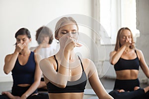 Group of young sporty people making Alternate Nostril Breathing photo