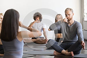 Group of young sporty people making Alternate Nostril Breathing photo