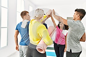 Group of young sporty people smiling happy high five with hands raised up at sport center