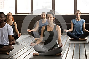 Group of young sporty people in Sukhasana pose