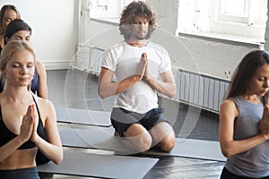 Group of young sporty people in vajrasana exercise