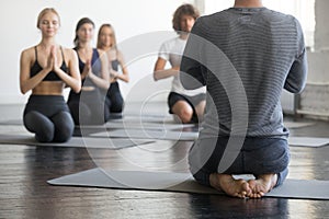 Group of young sporty people in vajrasana pose