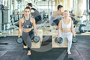 Group of young sporty people working out together in gym.