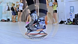 Group of young sporty women doing fitnes exercises with kangoo jumps shoes in a gym.