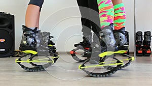 Group of young sporty women doing fitnes exercises with kangoo jumps shoes in a gym.