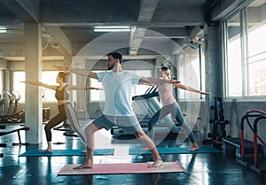 Group of young sporty yogi practicing yoga with instructor in gym., Sporty people in sportswear are working out training yoga in