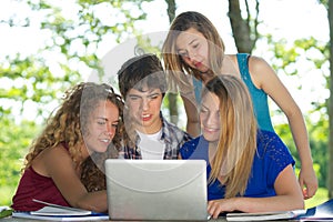 Group of young student using laptop outdoor