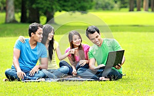 Group of young student using laptop outdoor