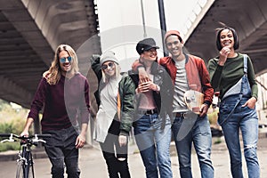 group of young stylish people walking outdoors