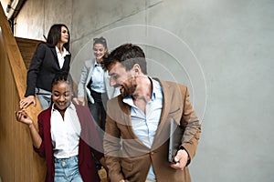 Group of young successful business people on stairs of office building happy with new ideas and satisfied with work support each