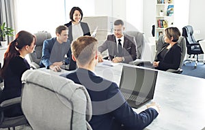 Group of young successful businessmen lawyers communicating together in a conference room while working on a project