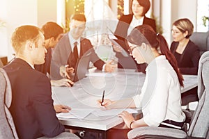 Group of young successful businessmen lawyers communicating together in a conference room while working on a project