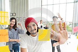 Group of young successful creative multiethnic team smiling and brainstorm together in modern office. Man and woman happy looking