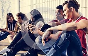 Group of young teenager friends chilling out together using smartphone social media concept photo