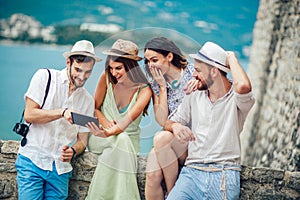 Group of young tourist friends with digital tablet