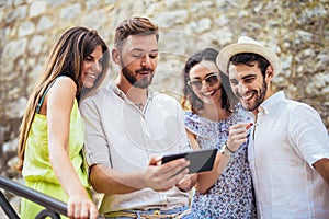 Group of young tourist friends with digital tablet