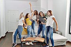 Group of young woman friends having party dancing at home