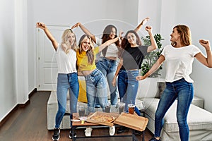 Group of young woman friends having party dancing at home