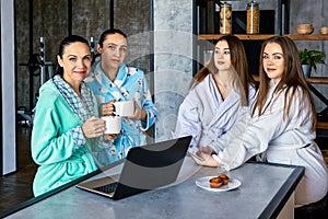 Group of young women confers during breakfast.