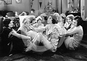 Group of young women sitting on the floor of a living room talking