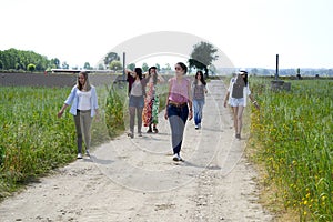 Group of young women walking on a field of wildflowers