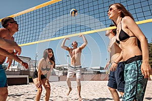 Group of youngpeople playing Volleyball on beach