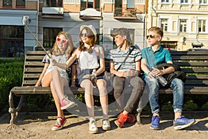 Group of youth is having fun together outdoors in urban background. Summer holidays, education, teenage concept.