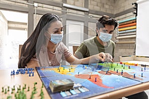 Group of youths with face masks playing a board game