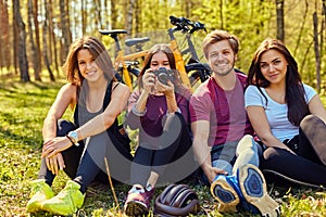 Groupe of people relaxing after bicycle ride in a forest.