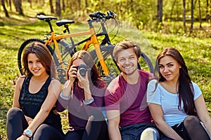 Groupe of people relaxing after bicycle ride in a forest.