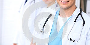 Groupe of unknown doctors standing straight in hospital office. Close Up of stethoscope at practitioner breast photo