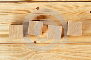 Groupped wooden square blocks on dark wooden table