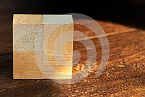 Groupped wooden square blocks on dark wooden table