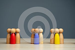 Groups of multicolored wooden people on a gray background. The concept of market segmentation. Target audience, customer care.
