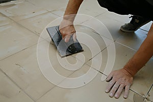 Grouting ceramic tiles, close up. Putting fugue on tiles on the floor