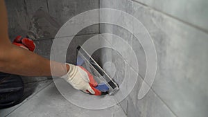 Grouting ceramic tiles. Tilers filling the space between tiles using a rubber trowel. Grouting ceramic tiles on the