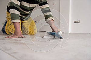 Tilers filling the space between ceramic wood effect tiles photo