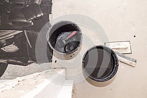 Grouting of tiles with black grout and grinding board and trowel