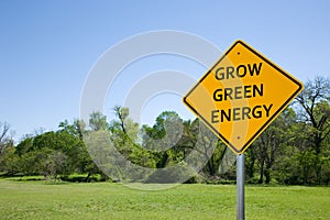 `GROW GREEN ENERGY` ROAD SIGN AGAINST BLUE SKY AND GREEN LANDSCAPE